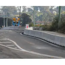 Long safety barriers lining a roadway construction zone to protect workers and guide traffic flow.